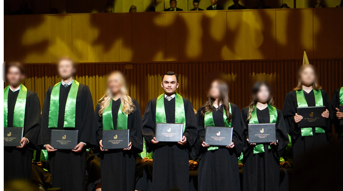 Adam Dahlqvist at the Jönköping University graduation ceremony, holding his diploma